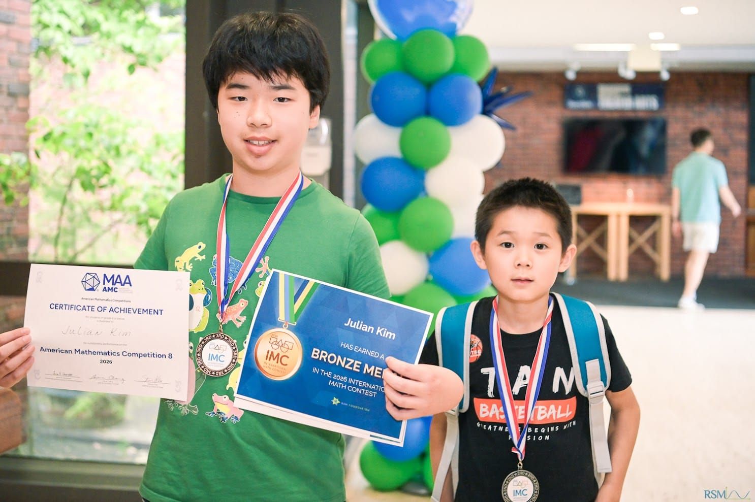 Julian Kim with math competition medals and certificates